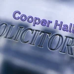 Cooper Hall Solicitors' branding displayed on a professional office sign, highlighting legal support for clients seeking to check CICA claim progress, resolve claim delays, and pursue criminal injury compensation claims