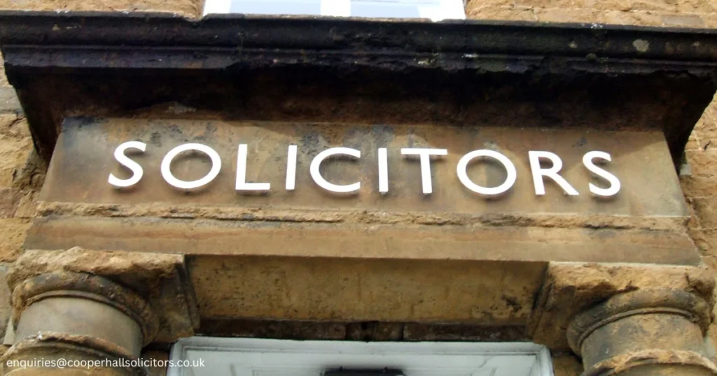 Close-up of a solicitor's office sign displayed on a historic building, representing legal services and expert advice on questions such as Can You Leave The Country On Bail, UK bail conditions, and criminal defence law.
